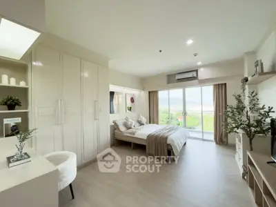 Spacious bedroom with modern decor and scenic balcony view