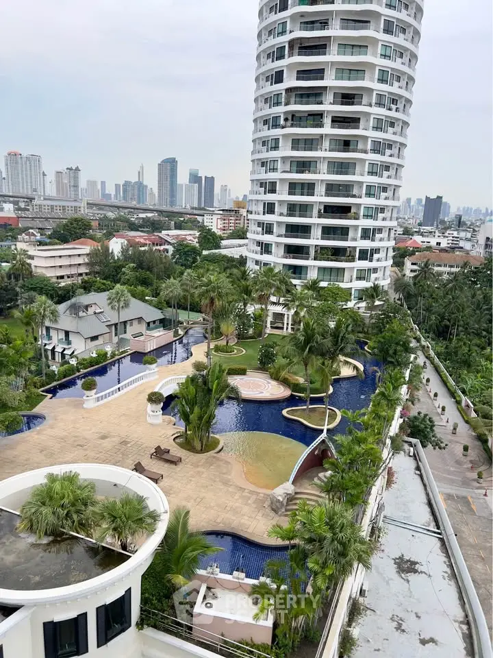Luxurious high-rise building with stunning pool and lush garden view in urban setting.