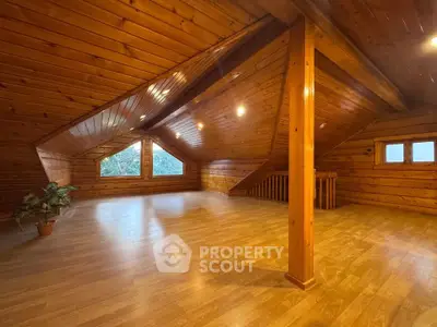 Spacious wooden attic with large windows and natural light