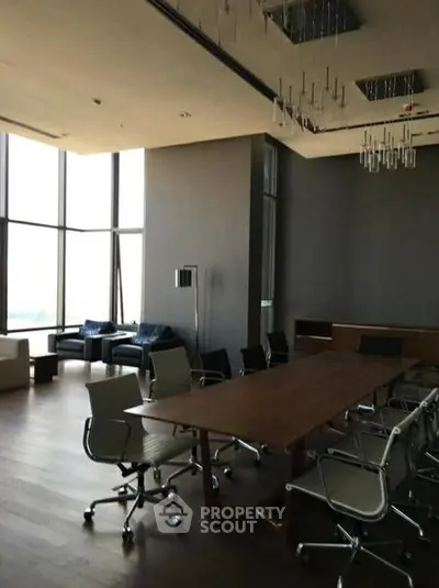 Spacious modern conference room with floor-to-ceiling windows and elegant furnishings.