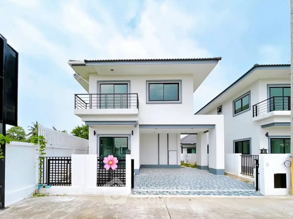 Modern two-story white house with balcony and spacious driveway