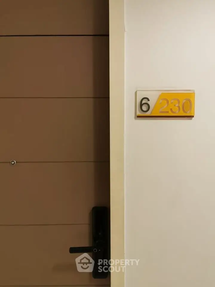 Modern apartment door with room number 230 on the sixth floor.