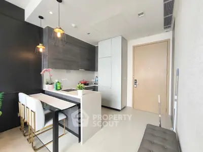 Modern kitchen with sleek design, featuring a breakfast bar and stylish lighting.