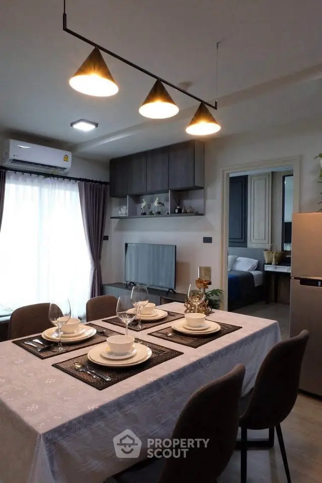 Modern dining area with elegant table setting and stylish lighting in a cozy apartment.