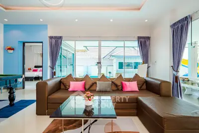 Spacious modern living room with large sectional sofa and pool view, perfect for relaxation and entertainment.