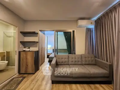 Modern living room with stylish sofa and wooden flooring in a cozy apartment setting.