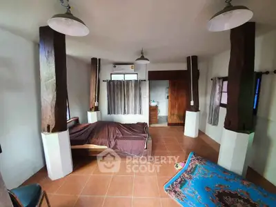 Spacious bedroom with rustic wooden beams and tiled flooring