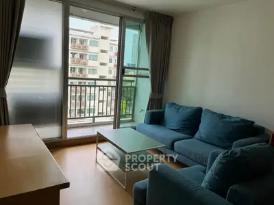 Cozy living room with blue sofas and balcony view in modern apartment