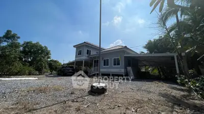 Charming countryside home with spacious yard and carport, surrounded by lush greenery.