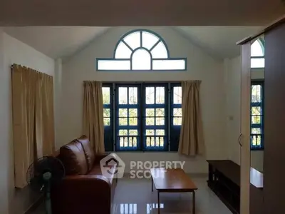 Charming living room with arched windows and cozy seating area.