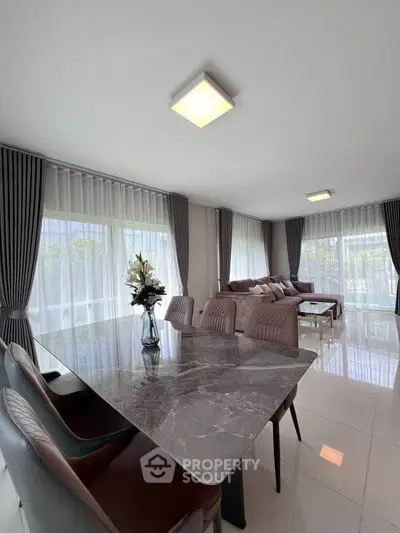 Spacious modern living room with elegant dining area and large windows.