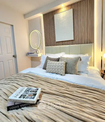 Luxurious bedroom with elegant decor and plush bedding, featuring designer books and ambient lighting.