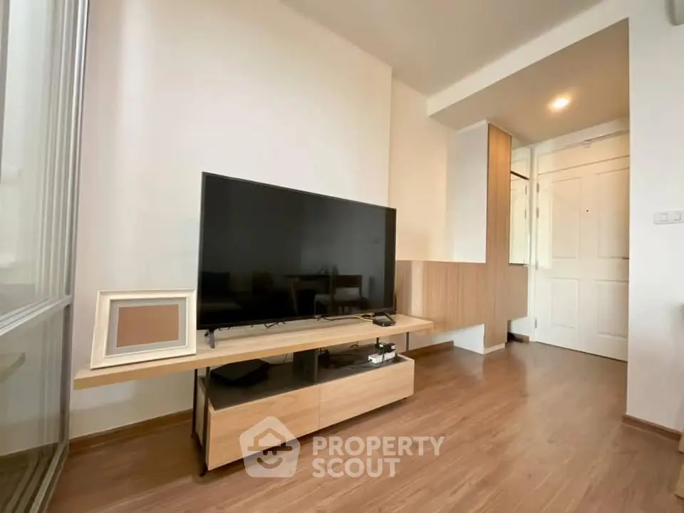Modern living room with sleek TV setup and wooden flooring