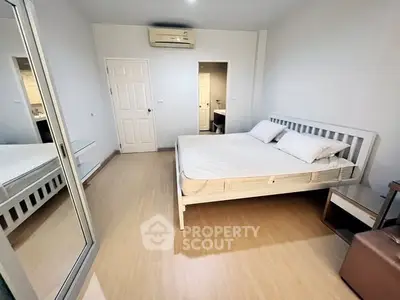 Spacious bedroom with modern design and mirrored wardrobe in a cozy apartment.