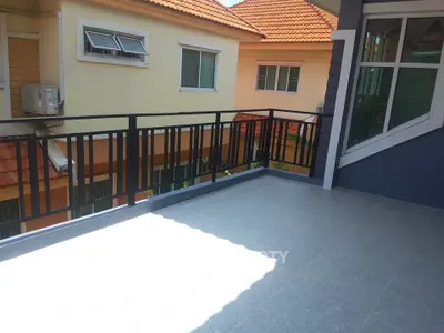 Spacious balcony with modern railing and tiled flooring, perfect for outdoor relaxation.
