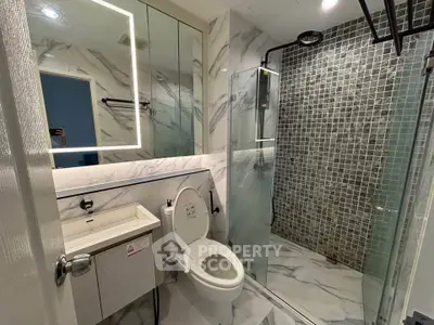 Modern bathroom with marble tiles and glass shower enclosure