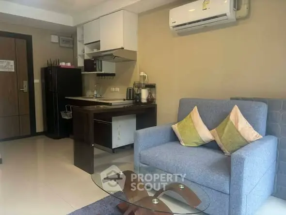Modern studio apartment with cozy living area and compact kitchen, featuring air conditioning and stylish decor.