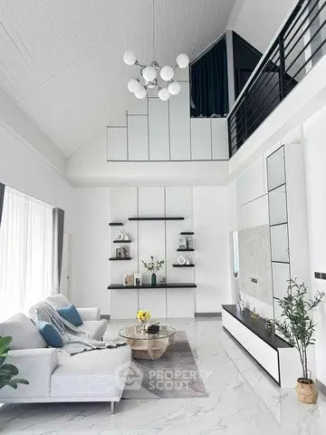 Stunning modern living room with high ceiling and mezzanine, featuring elegant decor and ample natural light.