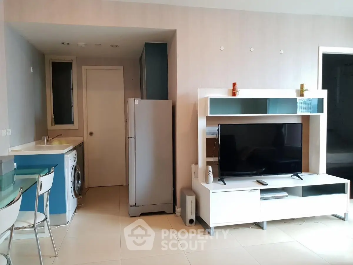 Modern living room with sleek TV unit and compact kitchen area
