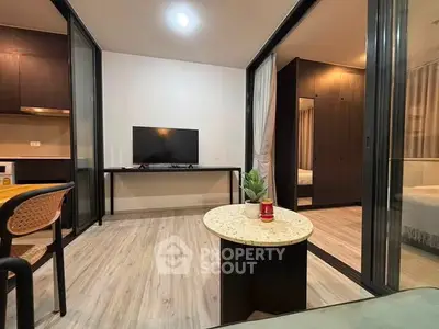 Modern living room with open layout and stylish decor, featuring a TV and cozy seating area.