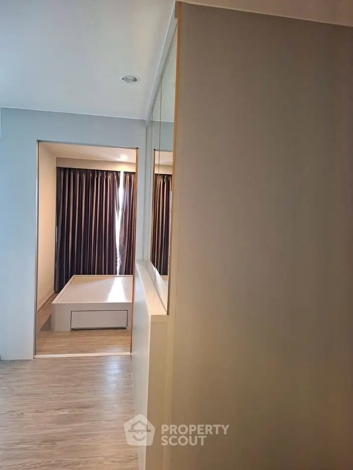 Modern bedroom with sleek design and natural light, featuring a stylish bed and elegant curtains.