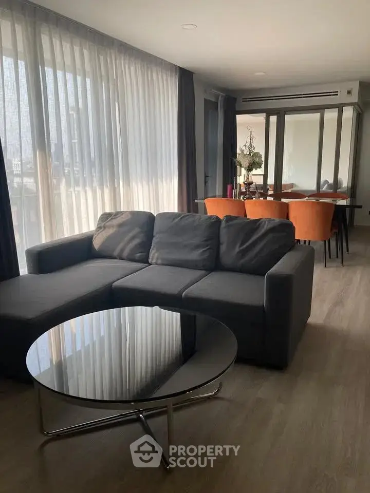 Modern living room with sleek furniture and large windows in a stylish apartment.