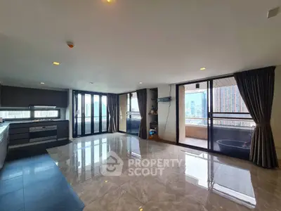 Spacious modern living room with open kitchen and city view balcony