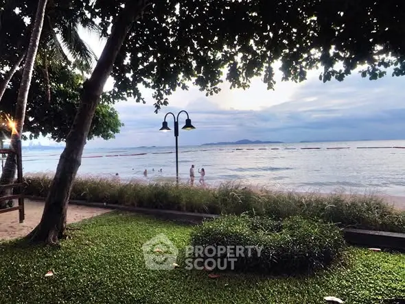 Stunning beachfront view with lush greenery and serene ocean waves.