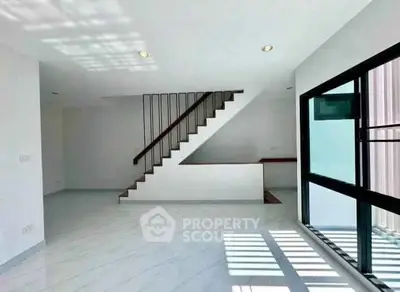 Spacious modern living room with sleek staircase and large windows