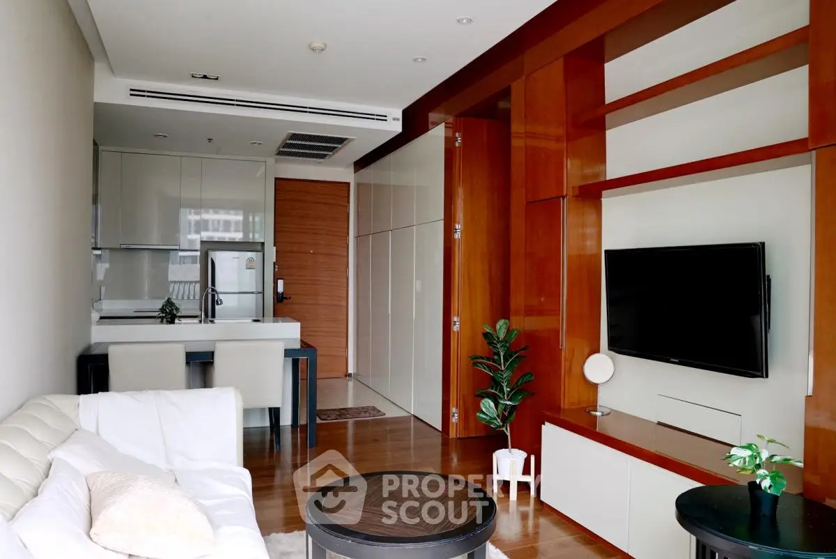 Modern living room with sleek kitchen, stylish furniture, and built-in TV unit in a contemporary apartment.