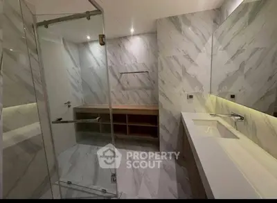 Luxurious modern bathroom with marble walls and spacious shower area