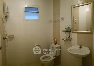 Modern bathroom with shower, toilet, and sink in a cozy apartment.