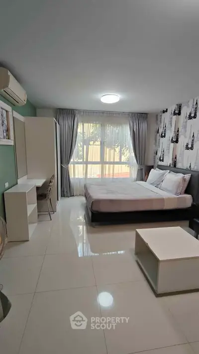 Spacious modern bedroom with large window and stylish decor