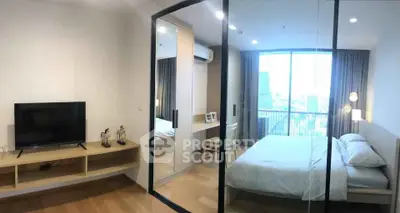Modern bedroom with city view, featuring mirrored closet and sleek furnishings.