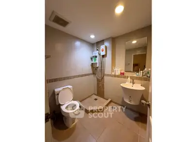 Modern bathroom with shower, toilet, and sink in a cozy real estate property.