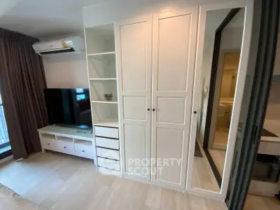 Modern bedroom with sleek white wardrobe and TV unit, featuring air conditioning and stylish decor.