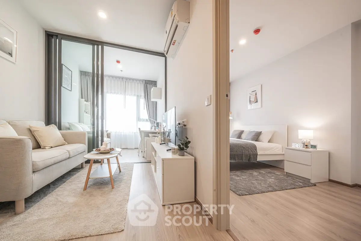 Modern open-plan living room and bedroom with stylish decor and natural light.