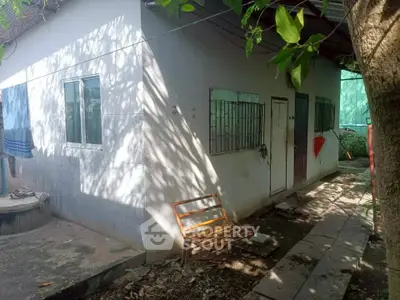 Charming small house with lush greenery and natural light, perfect for cozy living.