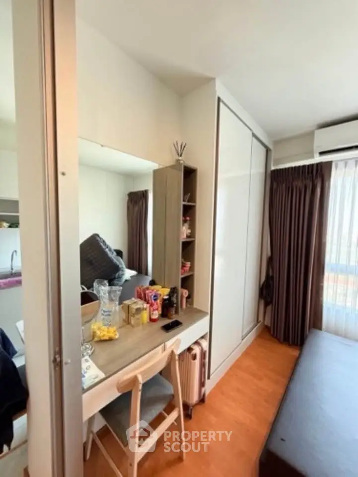 Cozy bedroom with modern furniture and ample natural light, featuring a stylish desk and wardrobe.