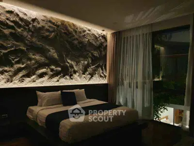 Luxurious bedroom with textured accent wall and large window overlooking greenery.