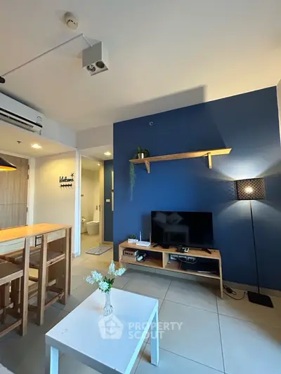 Modern living room with blue accent wall, stylish furniture, and natural light.