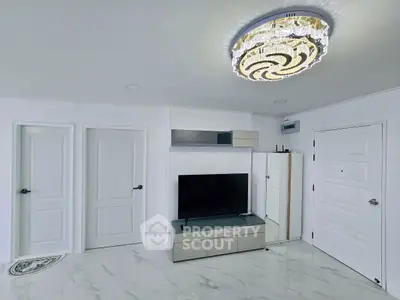 Modern living room with elegant chandelier and sleek TV setup