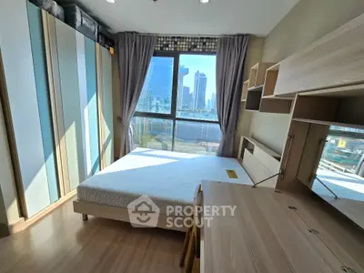 Modern bedroom with city view, featuring built-in storage and natural light.