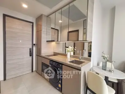 Modern kitchen with sleek appliances and dining area in stylish apartment