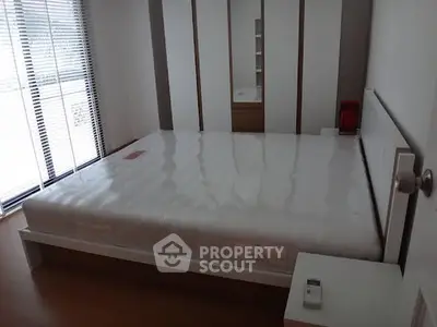 Spacious bedroom with large window and modern design, perfect for natural light lovers.