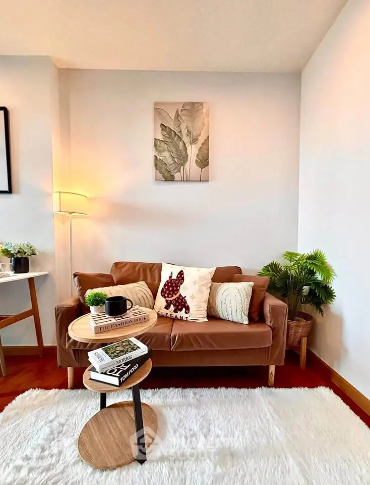 Cozy living room with stylish decor, featuring a leather sofa, modern coffee table, and lush indoor plants.