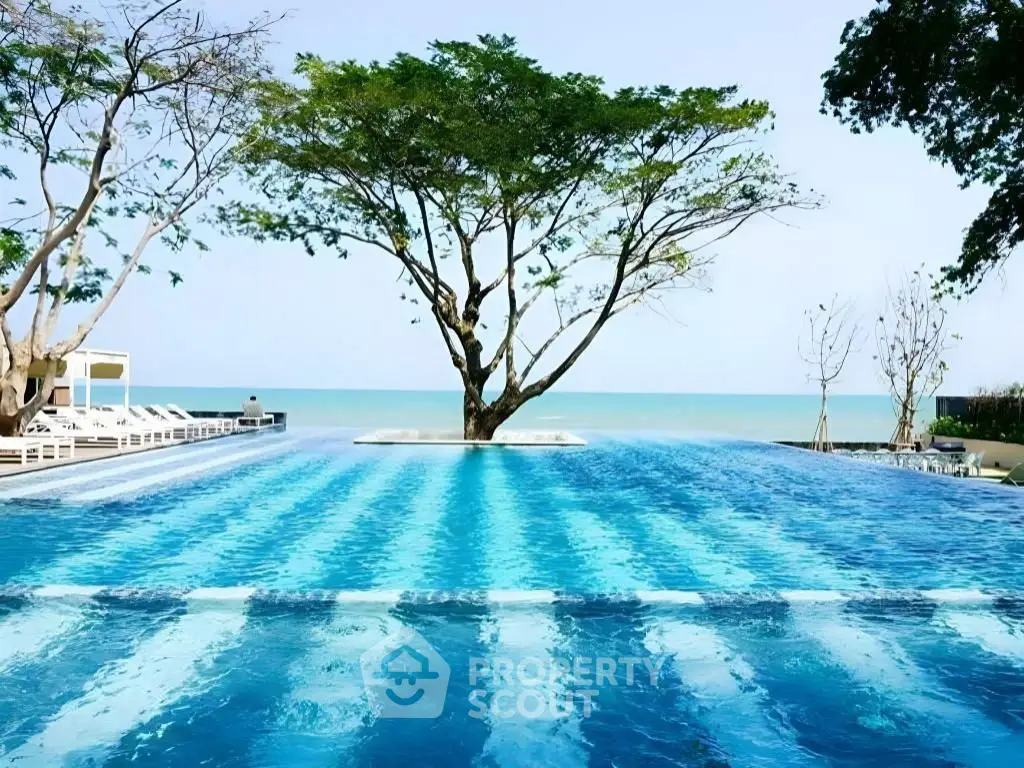 Stunning infinity pool with ocean view and lush greenery, perfect for luxury living.