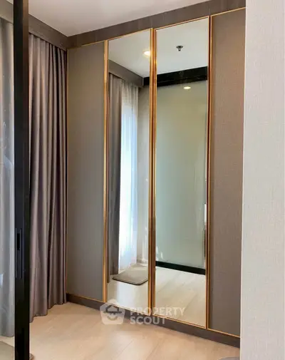 Elegant bedroom corner with mirrored wardrobe and soft lighting