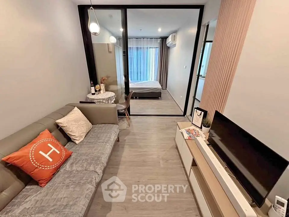 Modern living room with stylish decor and view into cozy bedroom, perfect for urban living.