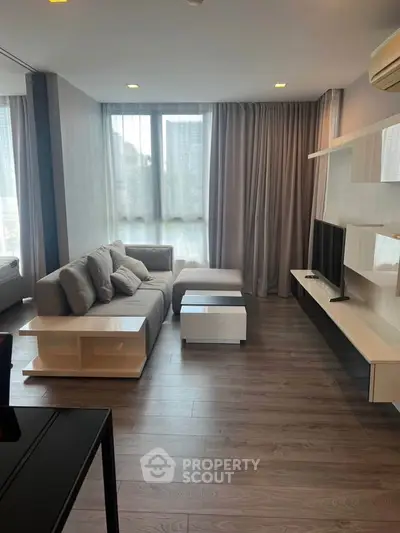 Modern living room with sleek furniture and large windows in a stylish apartment.